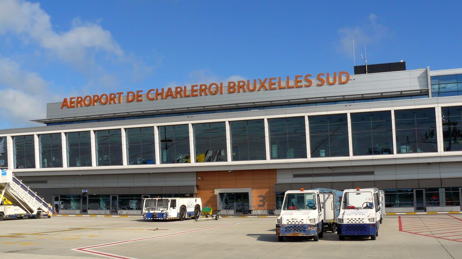 L'aérogare de l'aéroport de Charleroi Bruxelles-Sud vue depuis le tarmac, avec des véhicules de piste